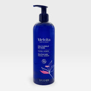 Melvita Organic Rose Hydrating Floral Water toner in a clear spray bottle, featuring a pink rose label and misting nozzle.