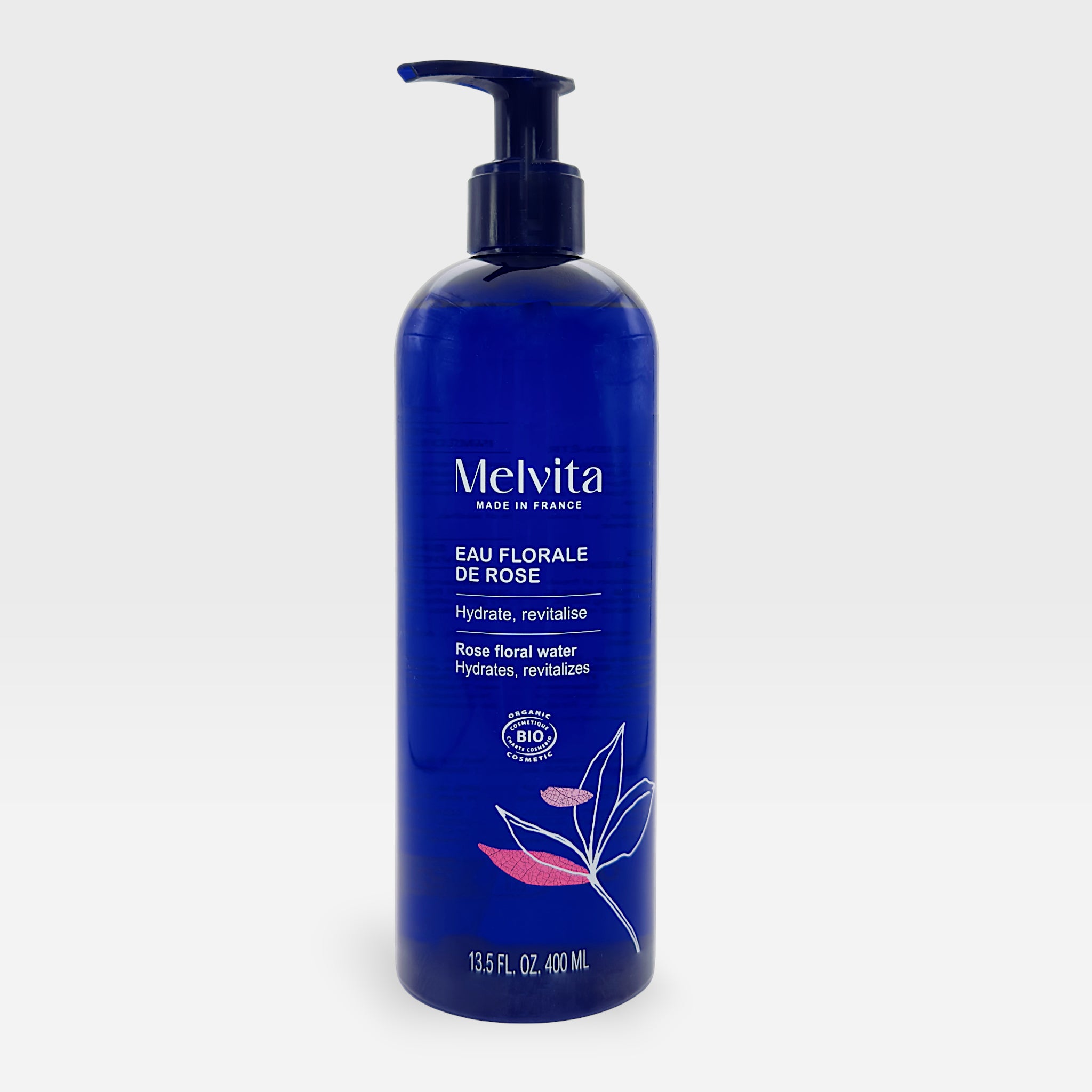 Melvita Organic Rose Hydrating Floral Water toner in a clear spray bottle, featuring a pink rose label and misting nozzle.