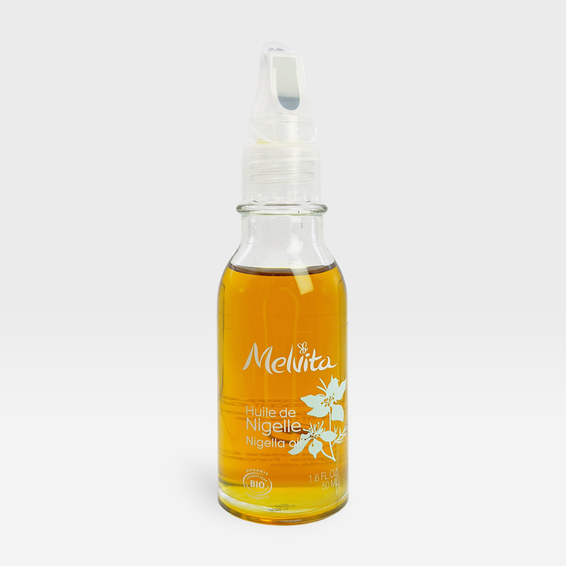 Melvita Organic Nigella Oil fluid in a 50ml bottle, showcasing the natural dark liquid inside the glass container.